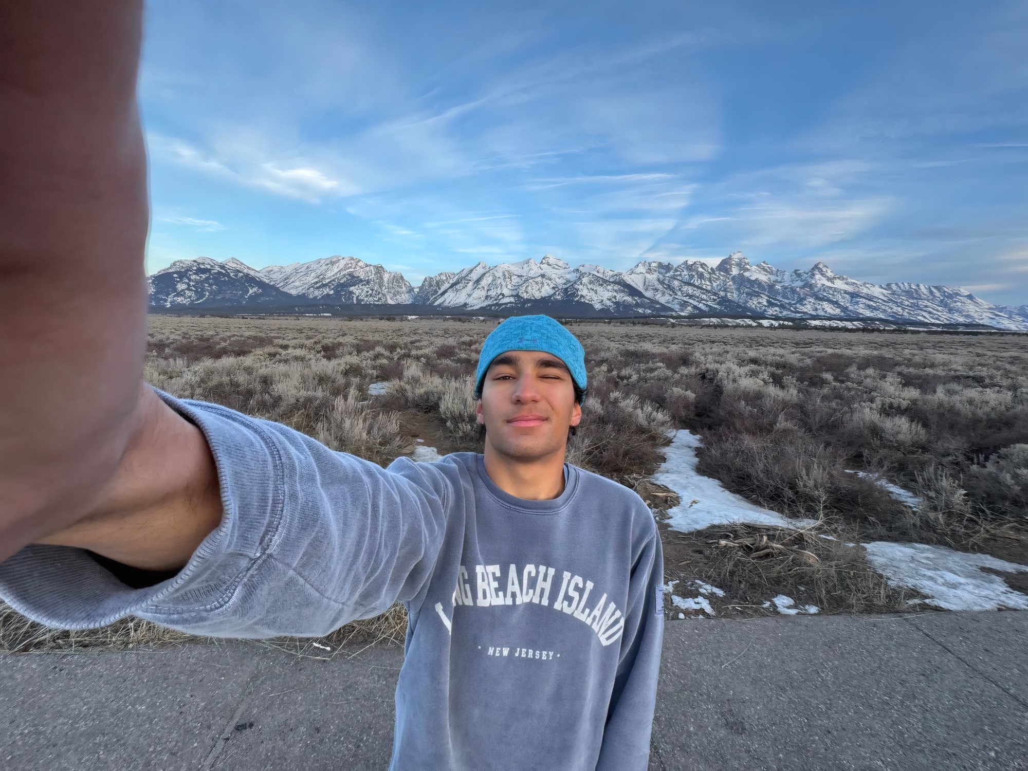 Kian taking a selfie in front of a snow-capped mountain range
