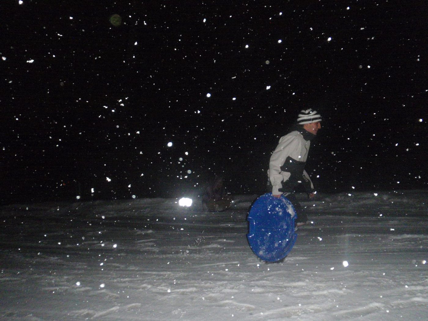Sledding at night in falling snow